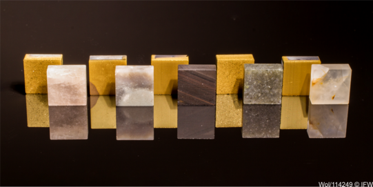 Gesteinseinsätze mit und ohne TiN-Beschichtung (von links nach rechts: Silberquarzit, Feuerstein, lamellarer Obsidian, Alta-Quarzit, Quarz)