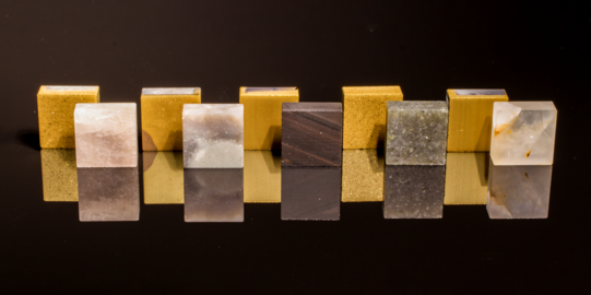 Gesteinseinsätze mit und ohne TiN-Beschichtung (von links nach rechts: Silberquarzit, Feuerstein, lamellarer Obsidian, Alta-Quarzit, Quarz)