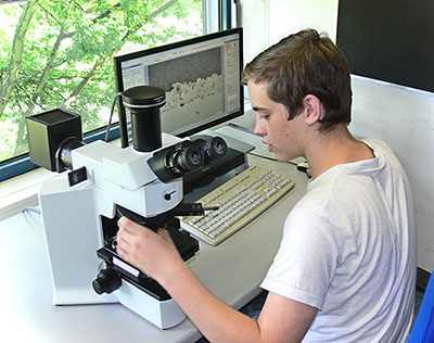 Werkstoffprüfung Person überprüft eine Probe am Mikroskop