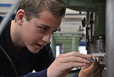 Zugversuch Person spannt Werkstück in Zugversuchmaschine